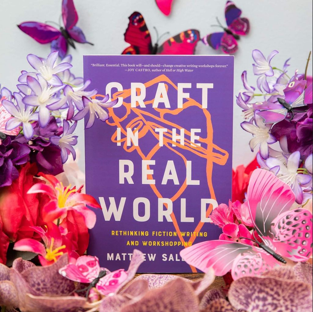 Photo of a purple book with an orange sketched hand. Title: Craft in the Real World by Matthew Salesses. Book is surrounded by purple and pink flowers and pink and purple butterflies.