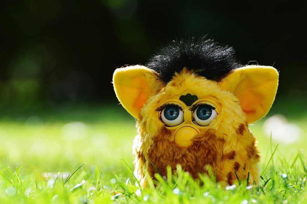 Image of a yellow furbie with black hair in grass.
Image sourced via Pixabay.