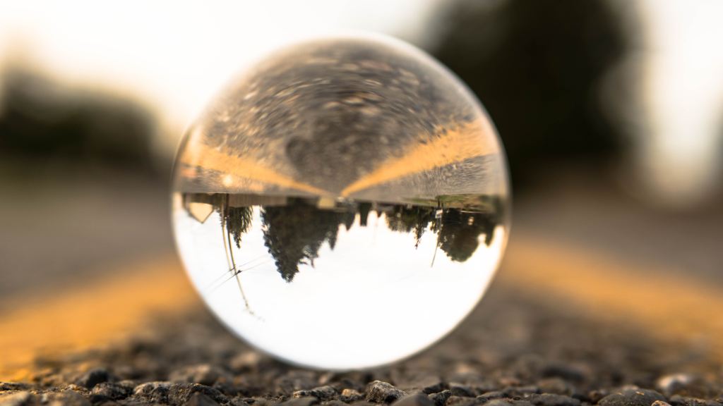 Photo of a crystal ball on a road showing an upside down town in the distance. 
Photo © Trevin Rudy on Unsplash